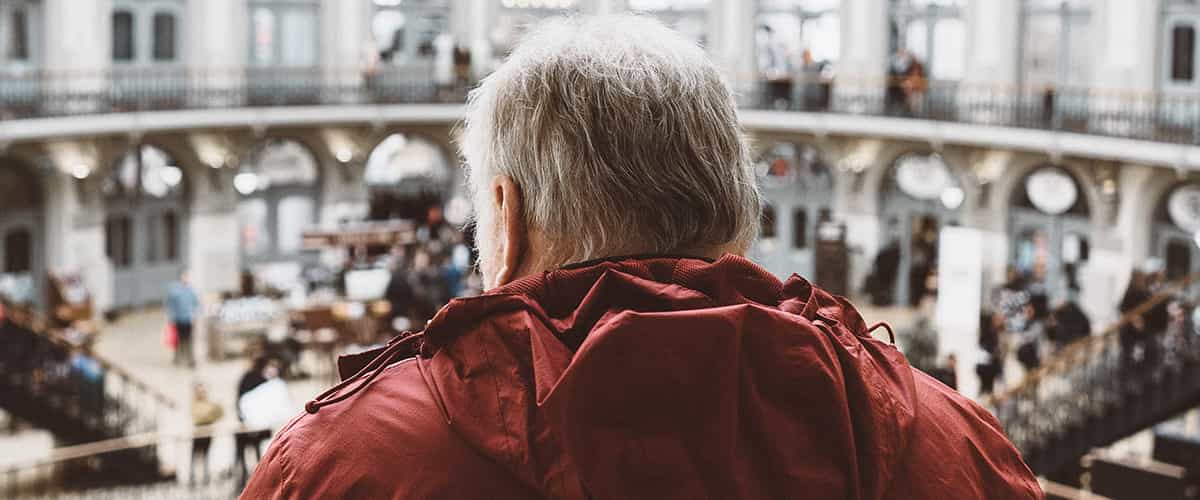 Man in red jacket looking out on the museum